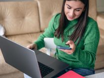 Business young woman with smartphone and laptop at home