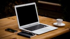 MacBook Air near mug on table