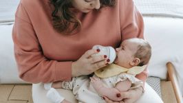 Mother feeding crying cute baby