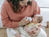 Mother feeding crying cute baby