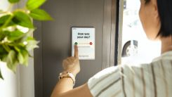 person holding white card near green plant