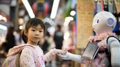 Photo of girl laying left hand on white digital robot